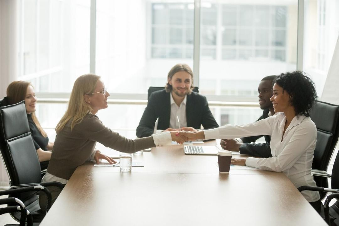 Business meeting with a handshake across the table